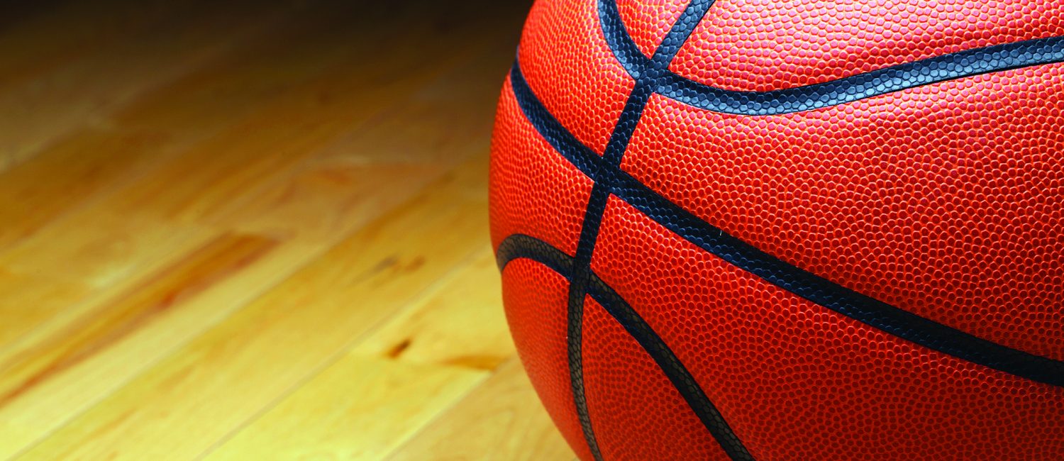 A large basketball in the shadow of the court