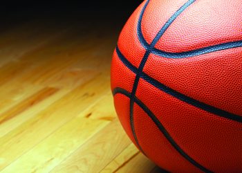 A large basketball in the shadow of the court