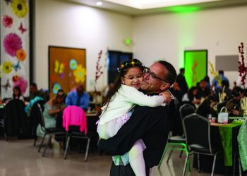 Father holds daughter at father-daughter dance